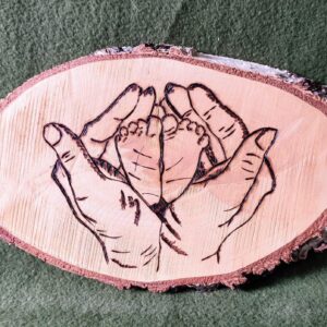 Pieds d'enfant pyrogravés sur rondin de bois